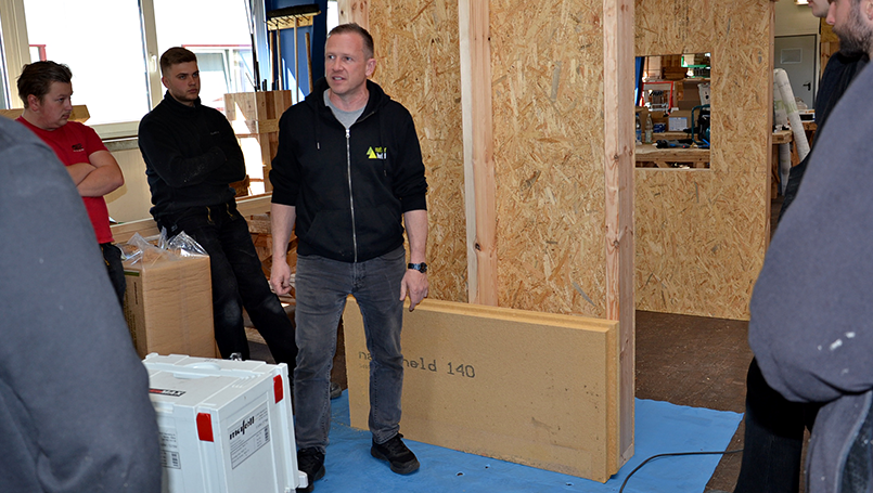 Bild 08 | Praxisorientierte Schulung für Auszubildende im Zimmererhandwerk: Dämmung, Luftdichtung und Fassaden im Holzbau abc Bau M-V GmbH Anbringen der druckfesten Dämmplatten an die Übungskonstruktion