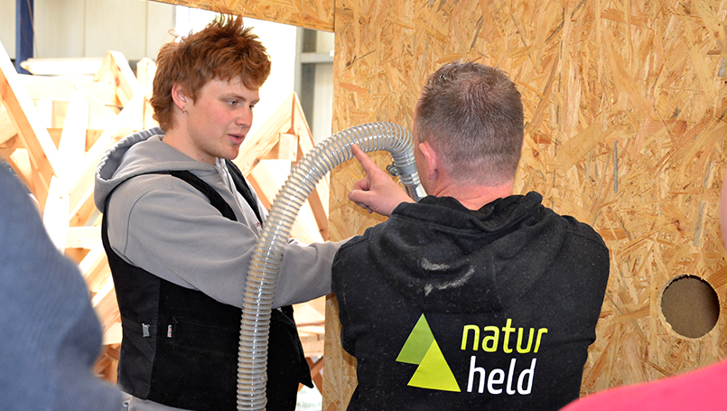Bild 15 | Praxisorientierte Schulung für Auszubildende im Zimmererhandwerk: Dämmung, Luftdichtung und Fassaden im Holzbau abc Bau M-V GmbH Einblasen der Naturheld FLOW Einblasdämmung in die Übungskonstruktion