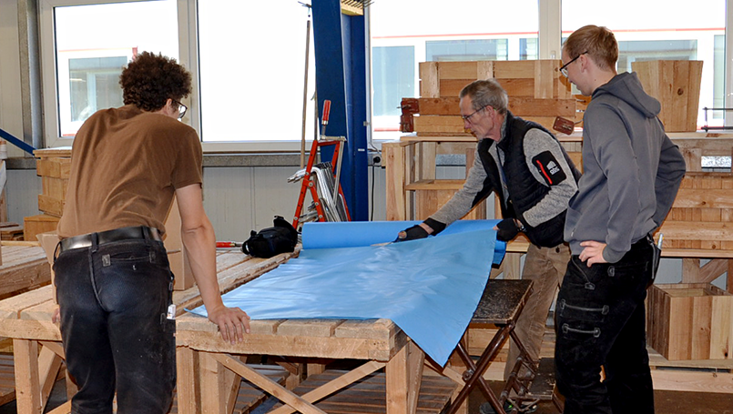 Bild 02 | Praxisorientierte Schulung für Auszubildende im Zimmererhandwerk: Dämmung, Luftdichtung und Fassaden im Holzbau abc Bau M-V GmbH Zuschneiden der Schutz-Plane