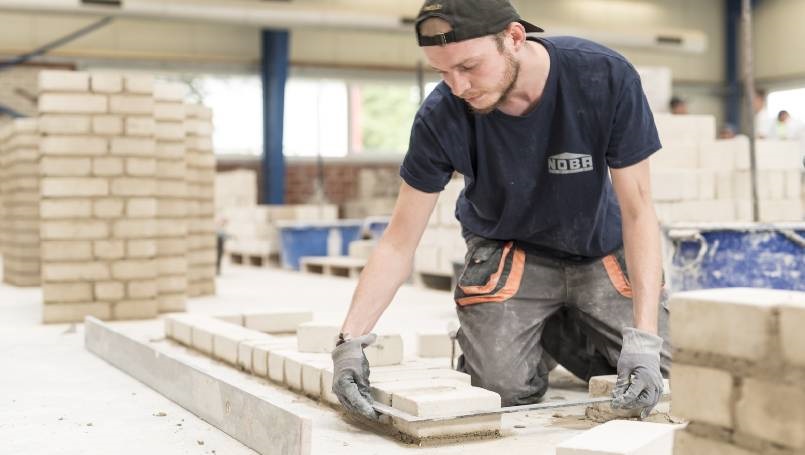 Mauerbau Ecke Maurer beim Anlegen einer Ecke